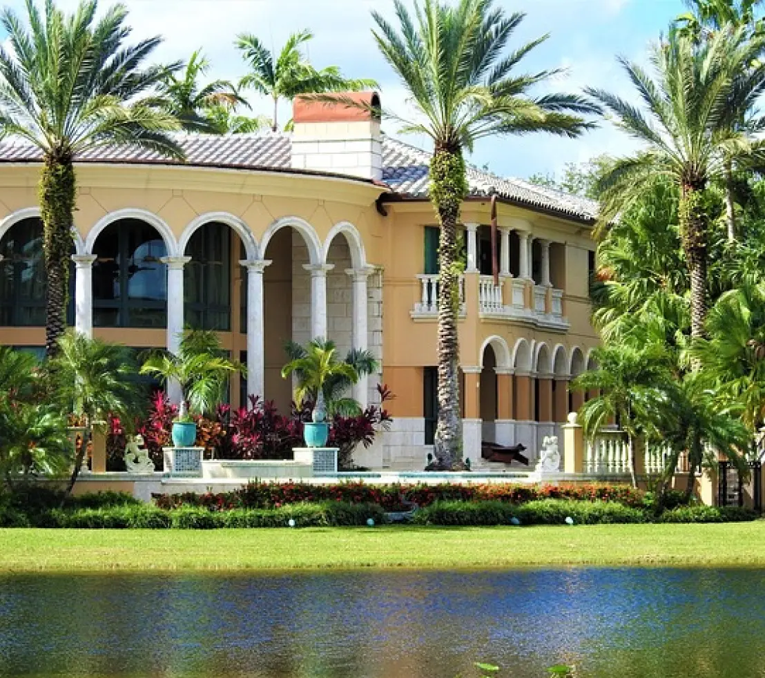 A large house with palm trees in the background.